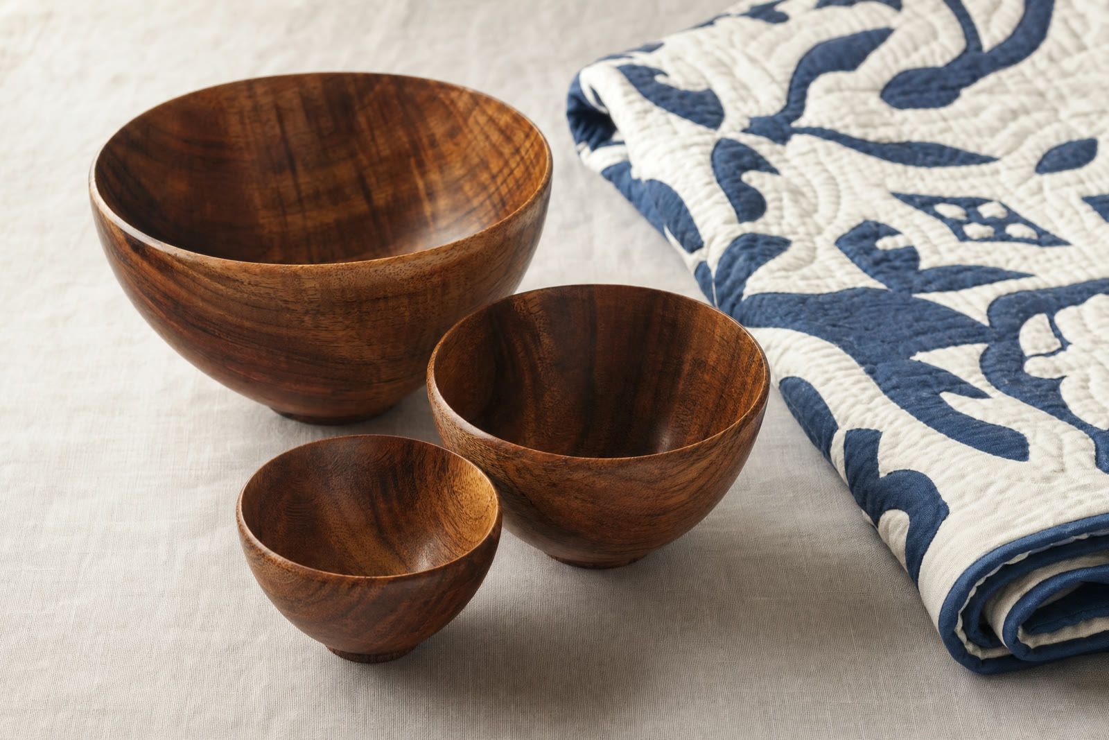 Turned koa bowls stacked on a pale surface